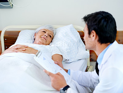 Buy stock photo Shot of a doctor discussing test results with his senior patient who is in a hospital bed