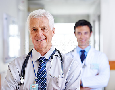 Buy stock photo Portrait of two smiling doctors standing in a corridor