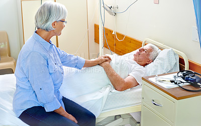 Buy stock photo Shot of a senior woman comforting her sick husband who is lying in a hospital bed