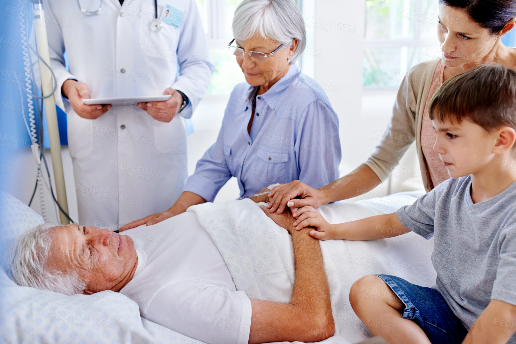 Buy stock photo Shot of a sick man in a hospital bed surrounded by his family