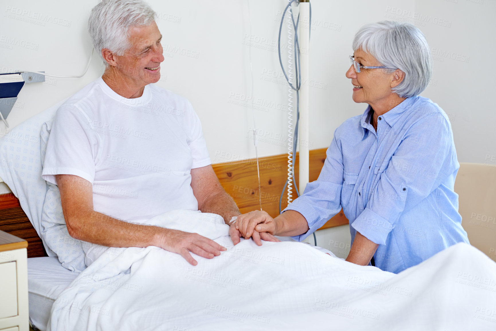 Buy stock photo Old couple, holding hands or man on bed for support in clinic for good news, patient or medical results. People, smile or happy visit for healthcare recovery, hope or senior treatment in hospital