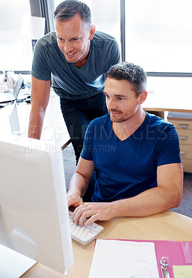 Buy stock photo Shot of two coworkers looking at a computer screen in an office