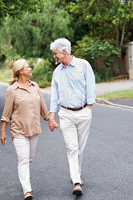 Buy stock photo Holding hands, road or old couple walking to relax or enjoy bonding together in retirement for peace. Happy, senior woman and elderly man on street with care, support or smile in quiet neighborhood