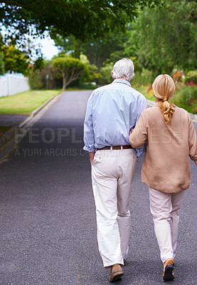 Buy stock photo Back view, road or old couple walking to relax and enjoy bonding together in retirement for peace. Love, senior woman and elderly man on street with care, support and health in quiet neighborhood