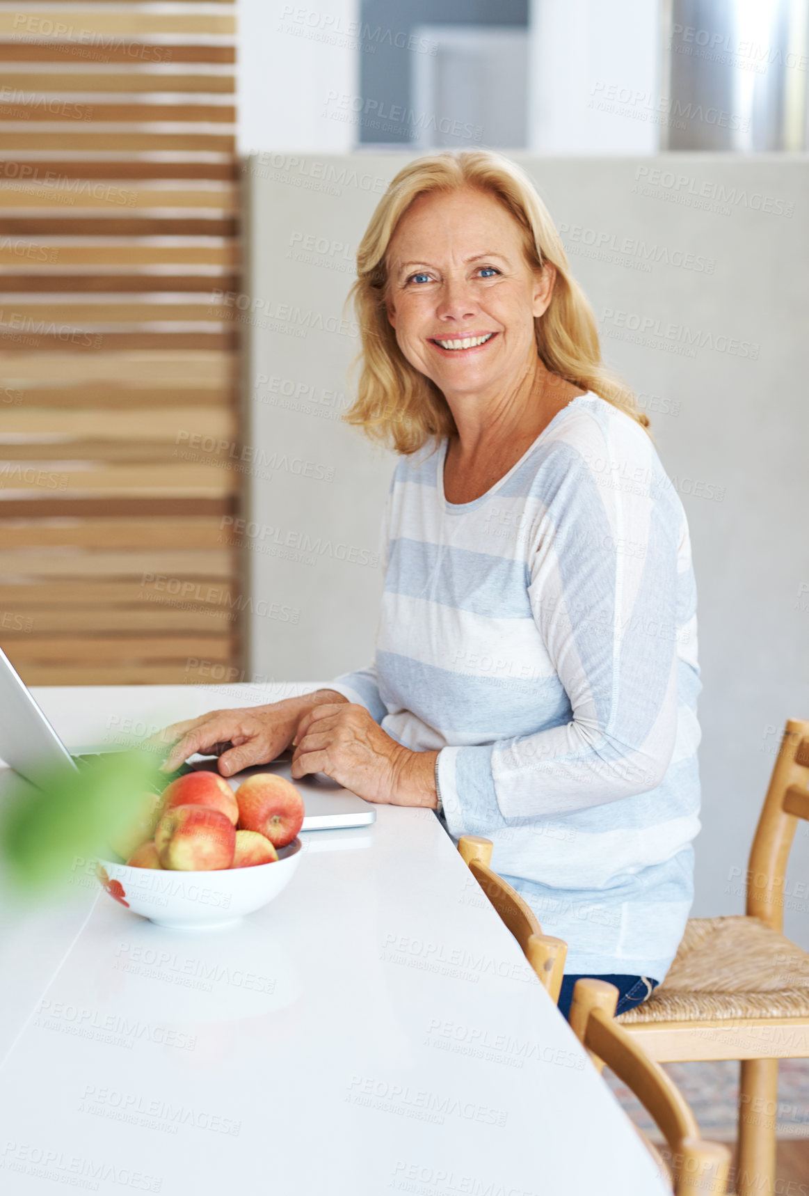 Buy stock photo Laptop, portrait and smile with senior woman in kitchen of home for browsing internet or research. Computer, remote work and trading for passive income with happy elderly person typing in apartment