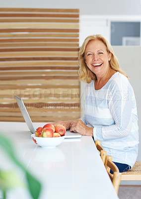 Buy stock photo Shot of a cheerful senior woman using her laptop at home