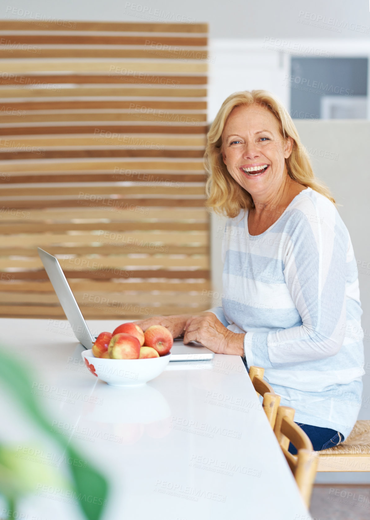 Buy stock photo Laptop, laughing and portrait with senior woman in kitchen of home for browsing internet or research. Computer, funny and trading for passive income with mature person in apartment for remote work