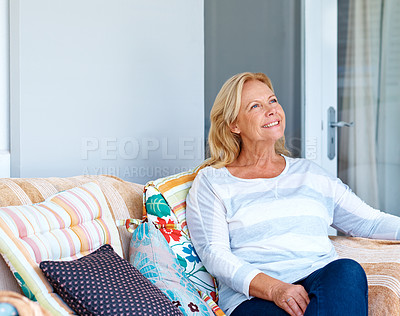 Buy stock photo Shot of a senior woman sitting outside while looking away