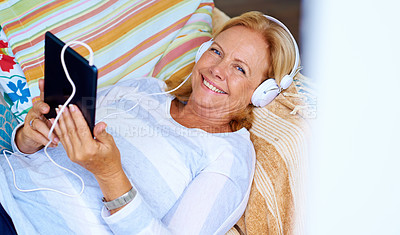 Buy stock photo Senior, woman and portrait with tablet on sofa for relax with music or podcast, happy and playing game. Elderly person, headphones and above on couch in home for reading ebook, streaming and smile.