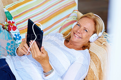 Buy stock photo Senior, woman and portrait with tablet on couch for relax with music or podcast, happy and playing game. Elderly person, headphones and internet on sofa in home for reading ebook, streaming and smile