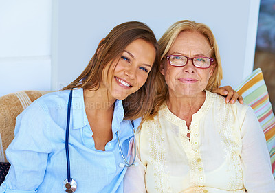 Buy stock photo Shot of a medical professional sitting lovingly next to her patient