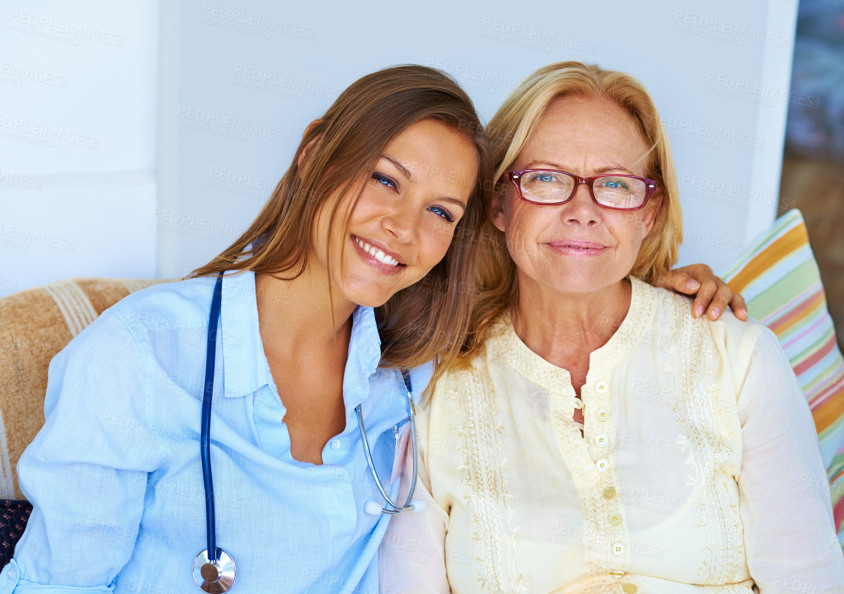 Buy stock photo Shot of a medical professional sitting lovingly next to her patient