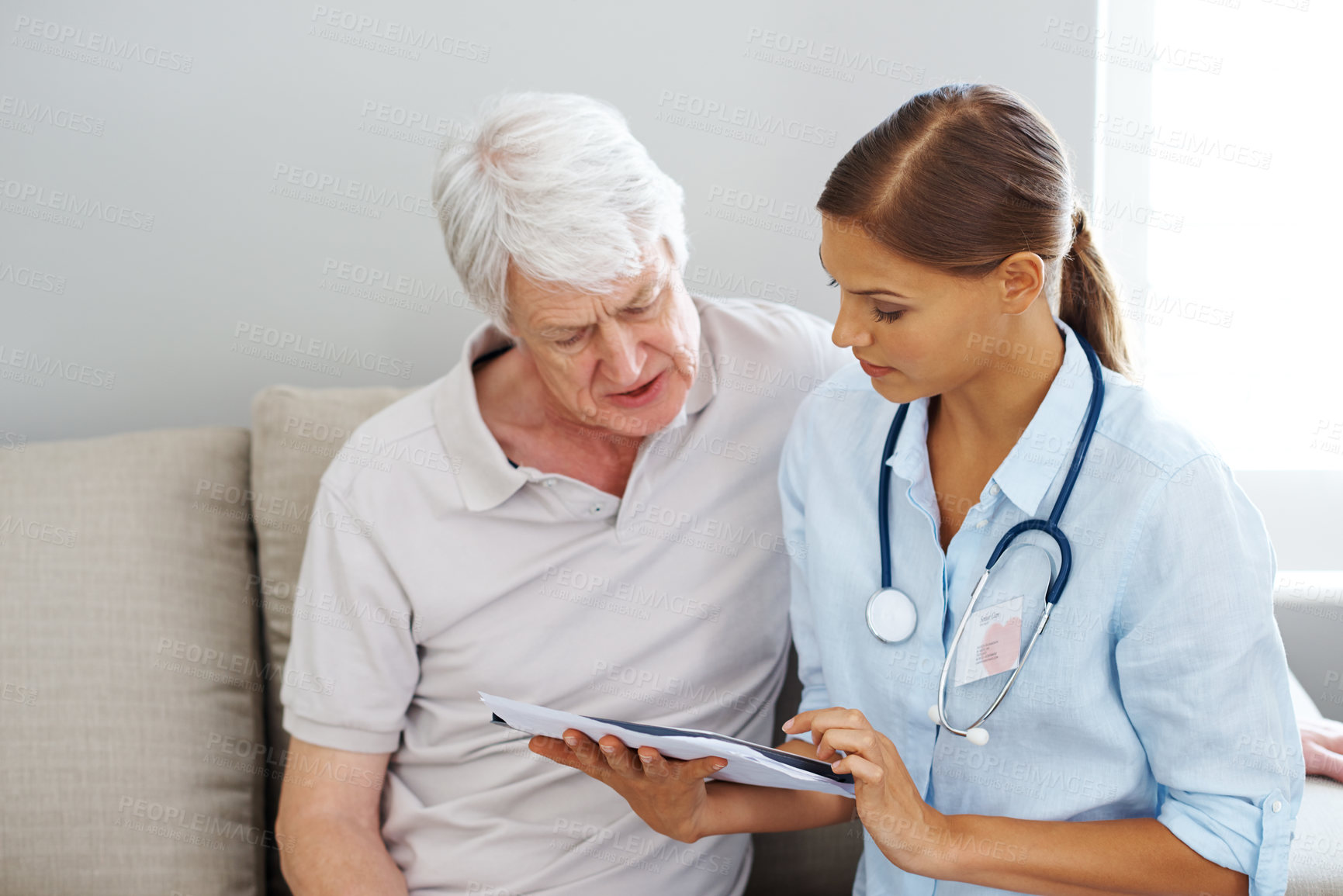 Buy stock photo Shot of a senior man and a young man looking at a digital tablet together