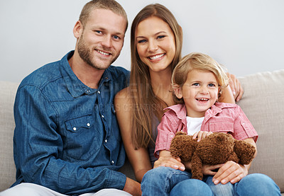 Buy stock photo Shot of a happy young family sitting in their home