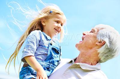 Buy stock photo Shot of a happy grandfather holding his young granddaughter
