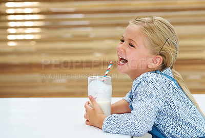 Buy stock photo Shot of a happy little girl enjoying a glass of milk