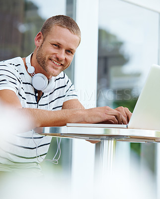 Buy stock photo Portrait of a  handsome young man working outside on a laptop
