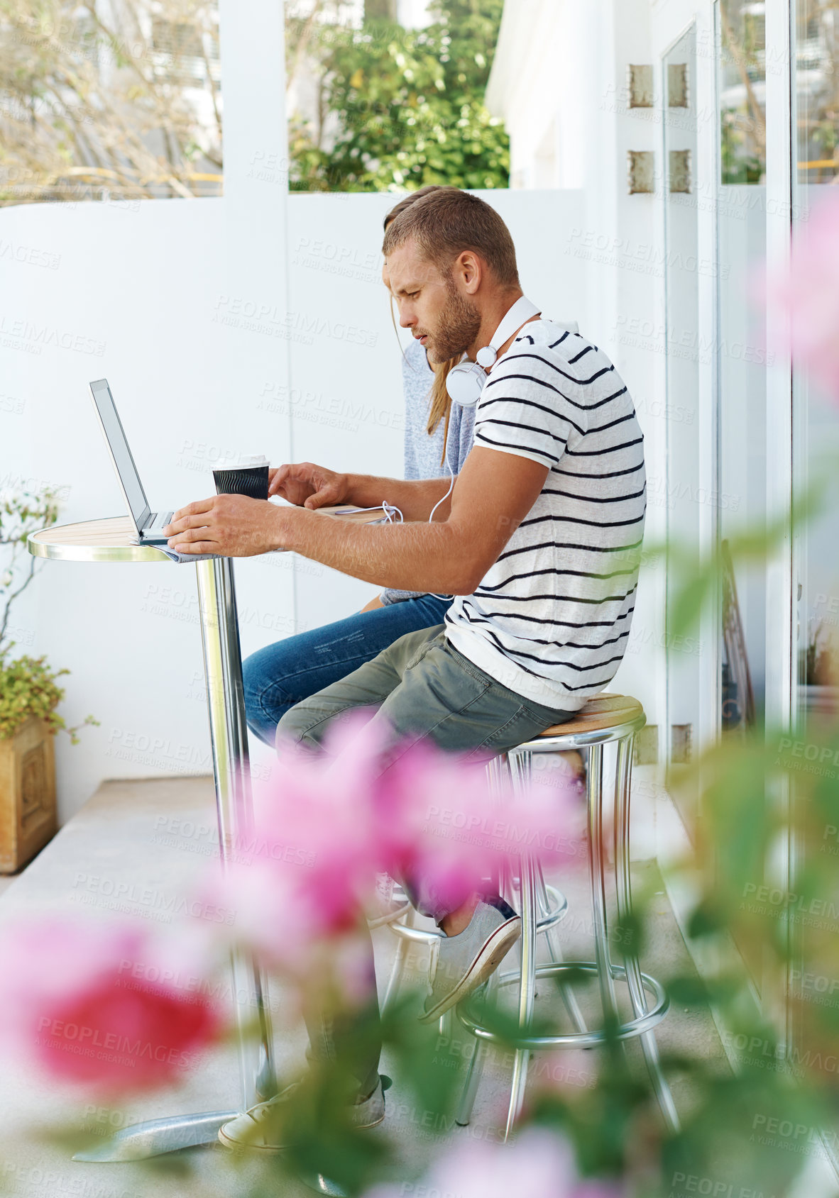 Buy stock photo Laptop, serious and man with headphones, coffee and freelancer with website, online or video editing. Outdoor, digital and creative in morning, typing and person with keyboard for remote work in cafe
