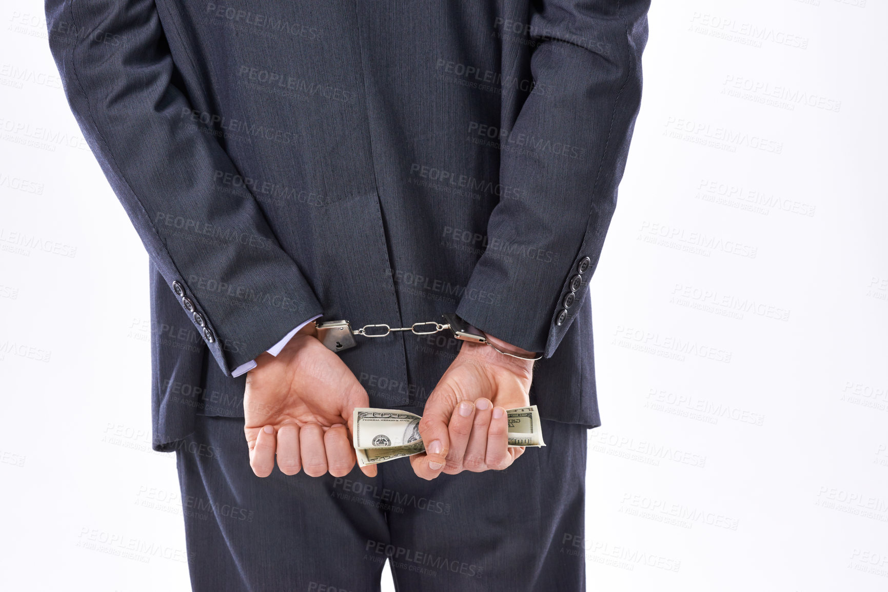 Buy stock photo Rear view studio shot of a businessman in handcuffs holding American Dollars