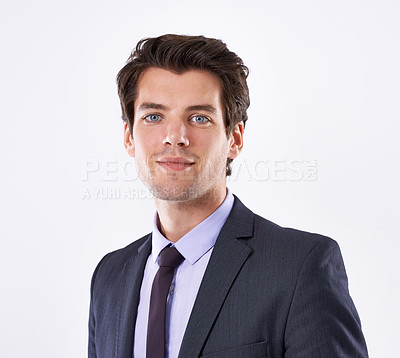 Buy stock photo Portrait of a young businessman standing against a studio background. Attractive professional male in a formal suit ready for an interview in the corporate industry. One confident accountant or lawyer