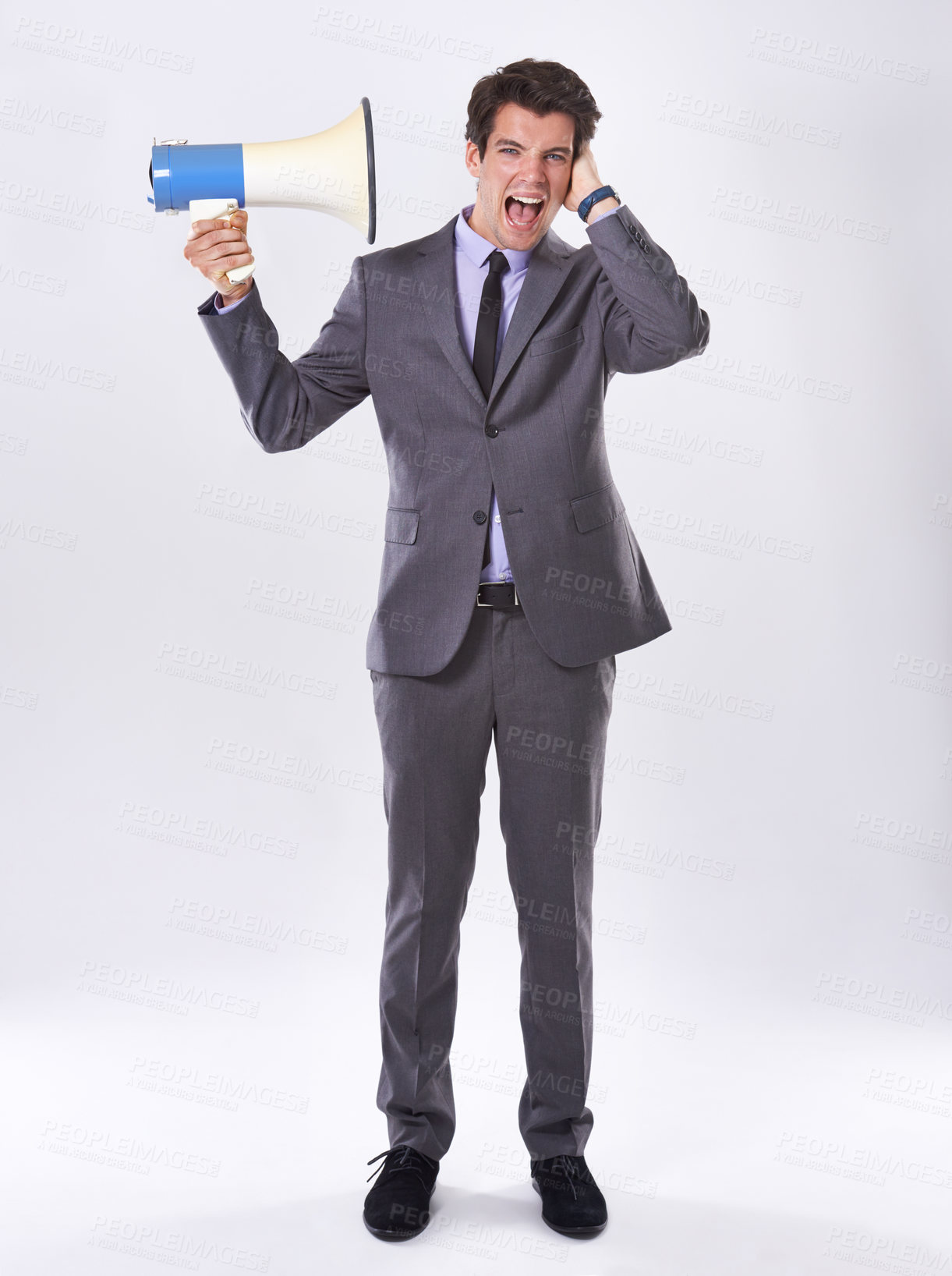 Buy stock photo Corporate man, loud and megaphone by ear in studio for communication, announcement or breaking news. Employee, noise and loudspeaker on white background for broadcast, warning and business propaganda