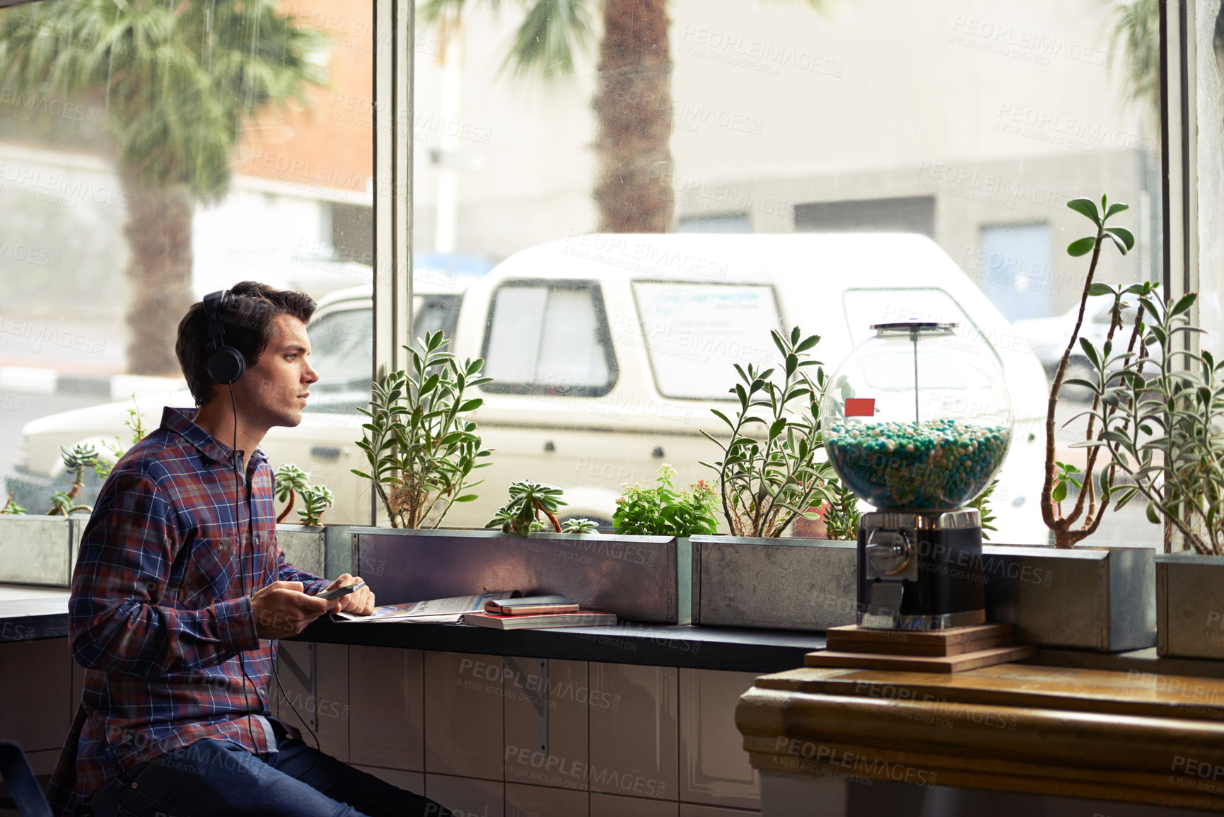 Buy stock photo Music, phone and window with man in coffee shop for break, hospitality or service as customer. Books, education and thinking with student in cafe or restaurant for development, learning or study