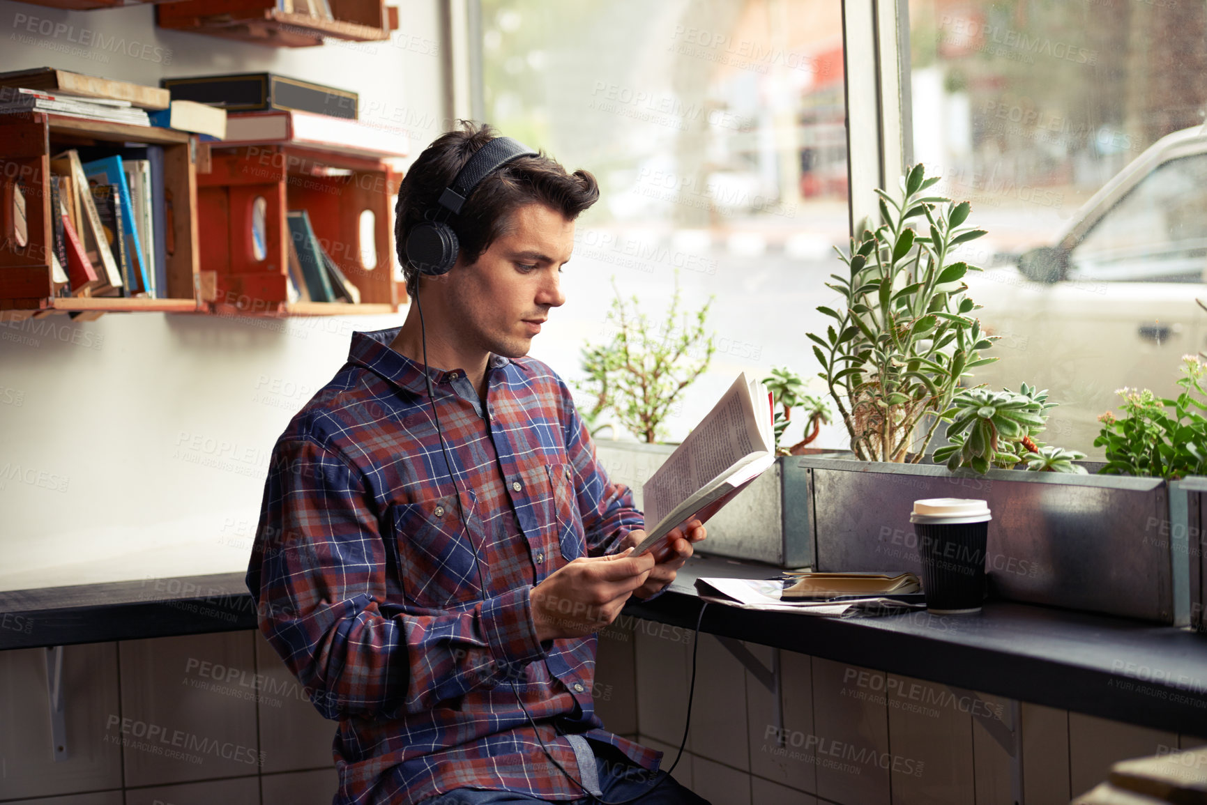 Buy stock photo Man, headphones and music for reading book at cafe, literature and student to study on campus. Male person, novel and learning english for journalism at coffee house, online and podcast for info