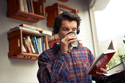 Buy stock photo Learning, headphones or man reading book at cafe for literature, education or history on campus. Music, drinking or studying english novel for journalism at coffee shop for tea beverage or podcast