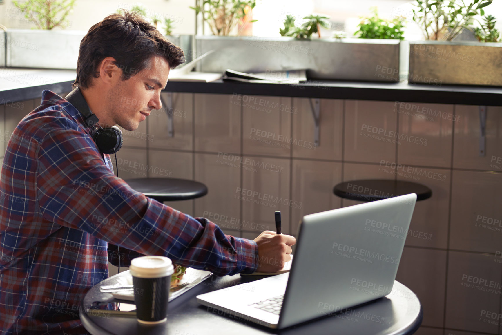 Buy stock photo Cropped shot of a young man working in a cafe during lunch 