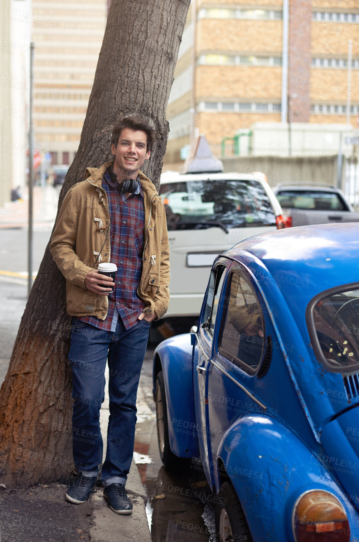 Buy stock photo Man, portrait and coffee in city for fashion, travel and confidence with headphones, tree and car. Male person, latte and happy outdoor by sidewalk for style, cool and trendy in morning in London