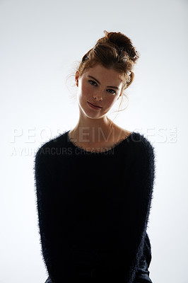 Buy stock photo Cropped studio portrait of an attractive young woman wearing a black sweater