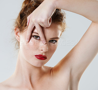 Buy stock photo Cropped studio shot of a beautiful young woman posing against a gray background