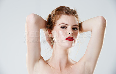 Buy stock photo Studio portrait of a beautiful young woman posing with her hands behind her head