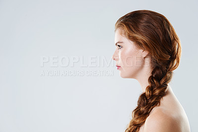 Buy stock photo Cropped side view of a beautiful young woman with braided hair standing against a gray background