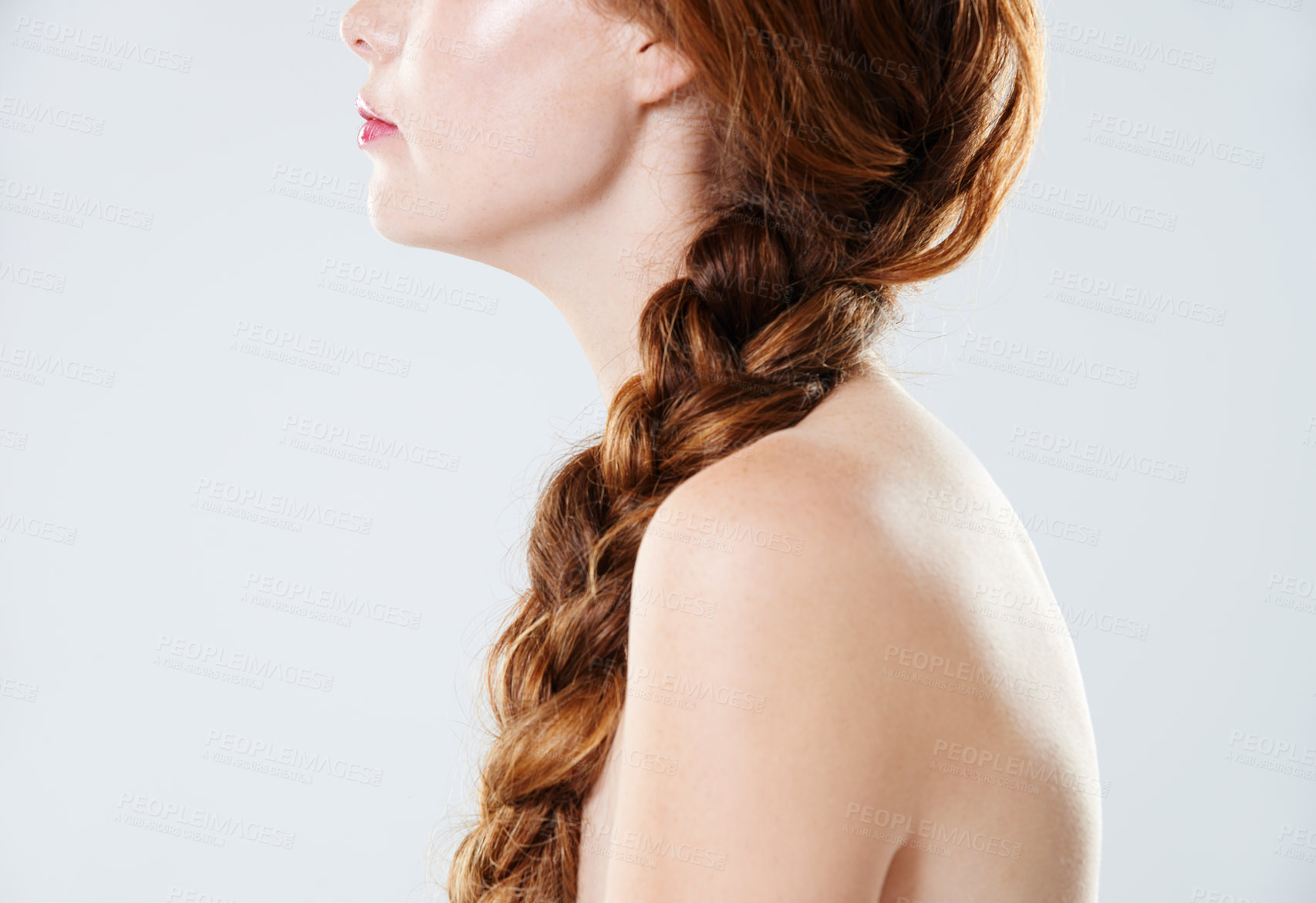 Buy stock photo Closeup of a woman with braided red hair isolated against grey background in studio with copyspace. Zoomed in on model posing shirtless and topless. Confident gorgeous redhead with french plait