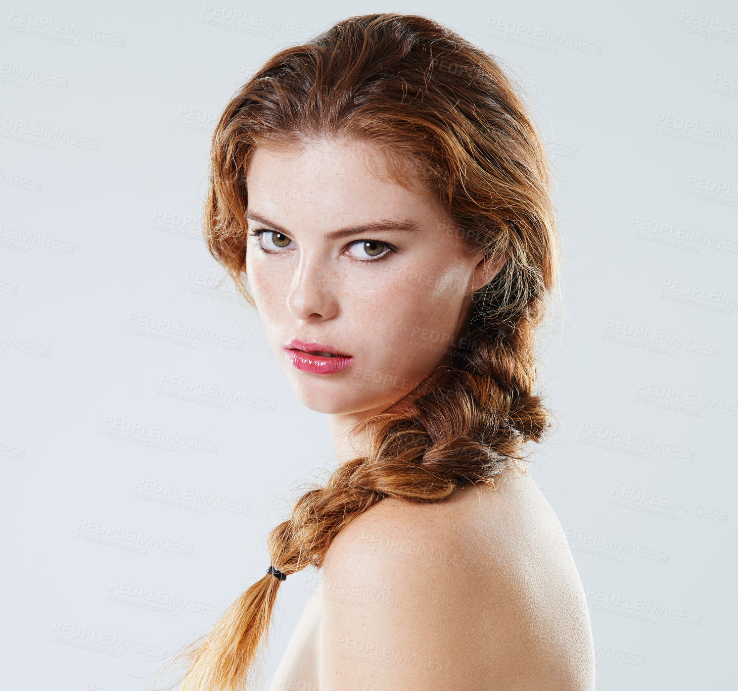 Buy stock photo Studio portrait of a beautiful young woman with braided hair looking over her bare shoulder