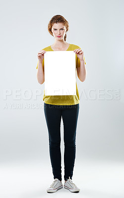 Buy stock photo Full-length studio portrait of an attractive young woman holding up a white placard with copyspace