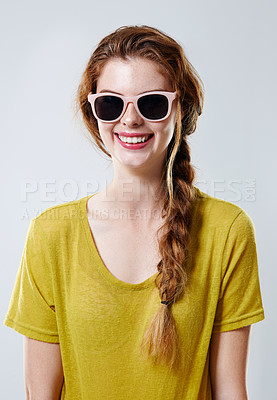 Buy stock photo Studio portrait of an attractive young woman wearing trendy sunglasses isolated on gray