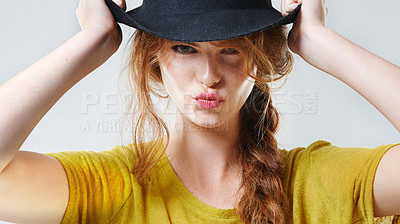 Buy stock photo Closeup studio portrait of a beautiful young woman pouting while wearing a black hat