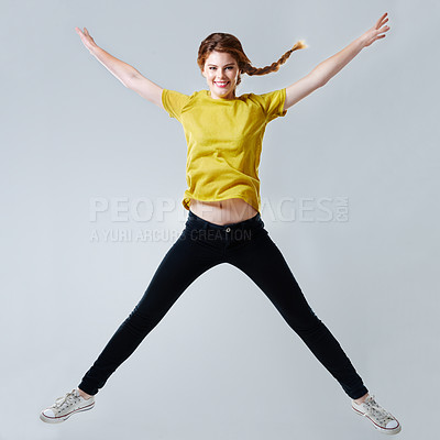 Buy stock photo Full-length studio shot of a beautiful young woman doing a star jump
