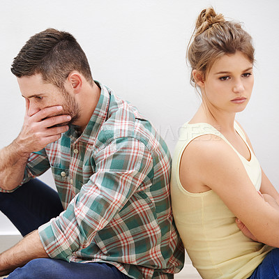 Buy stock photo Shot of a young couple having relationship difficulties sitting back to back
