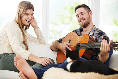 Buy stock photo Woman, man and playing guitar for relax, together and relationship with love or support in home. Happy couple, instrument and music for fun, bonding and comfort in lounge for session, peace or memory