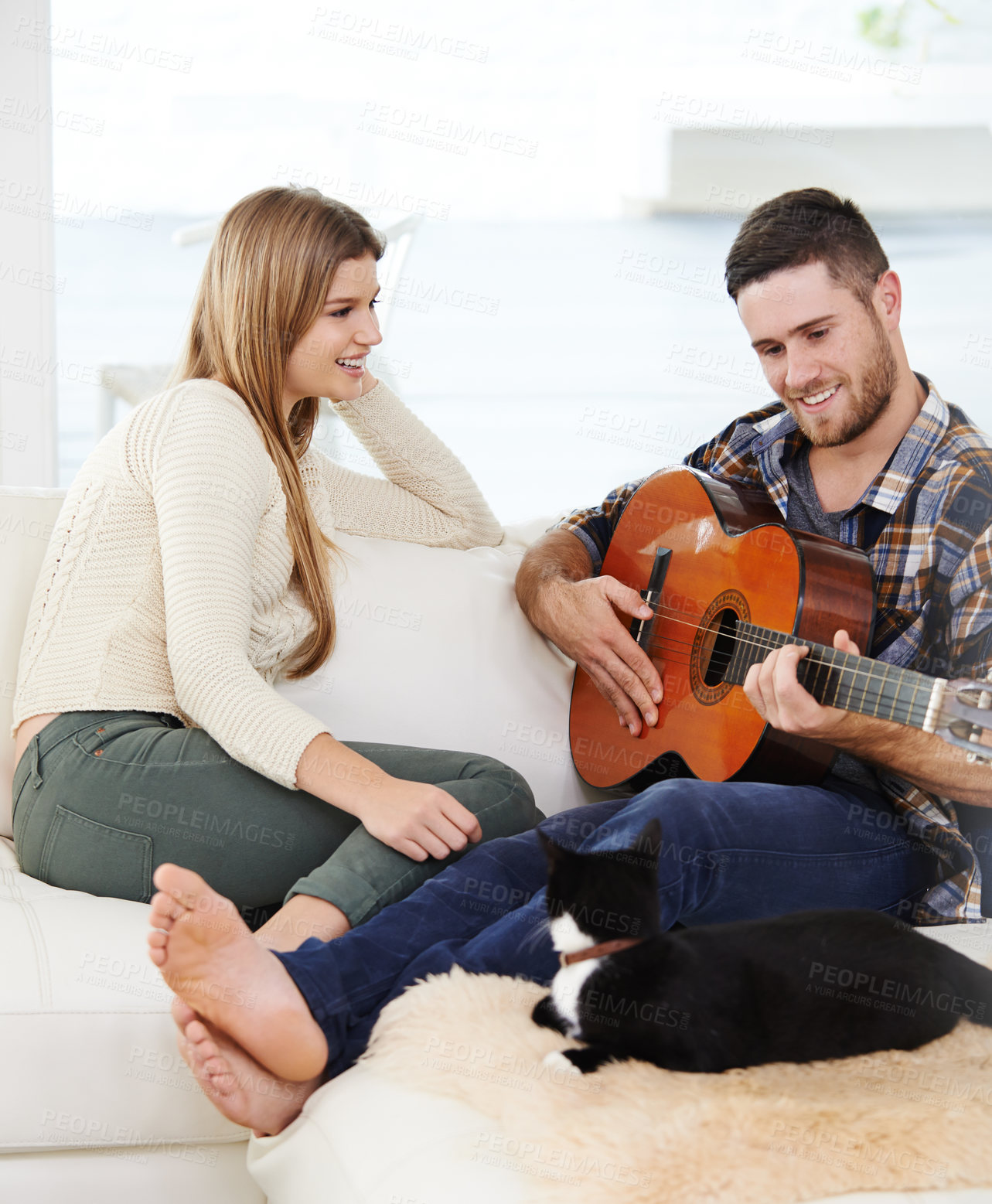 Buy stock photo Happy couple, home and playing guitar for relax, together and relationship with love or support. Woman, man and music instrument for fun, bonding and comfort in lounge for session, peace or memory