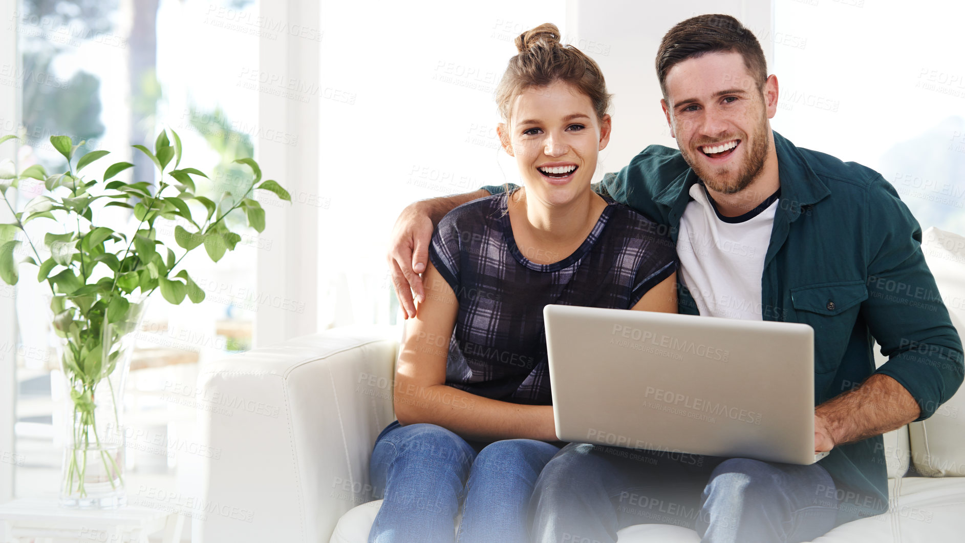 Buy stock photo Portrait of a happy young couple using a laptop while relaxing at home together