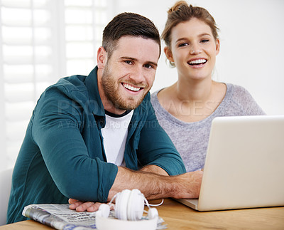 Buy stock photo Portrait of a smiling young couple using a laptop while relaxing at home together