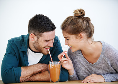 Buy stock photo Shot of an attractive young couple sharing a milkshake together
