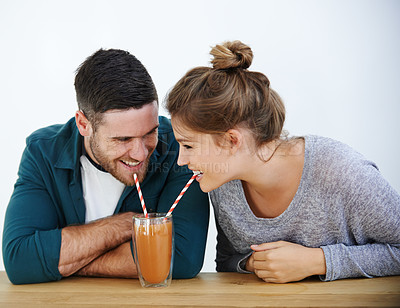 Buy stock photo Love, milkshake and laugh with couple on date for romance, bonding and happiness. Smoothie, coffee shop and care with man and woman sharing drink at restaurant for summer, break and relationship