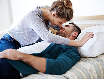Buy stock photo Happy romantic couple cuddling on their bed. Young newlywed husband and wife hugging and sharing an intimate moment in the bedroom. Affectionate lovebirds embracing and enjoying a cozy moment at home