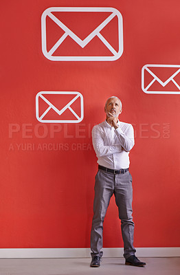 Buy stock photo A mature businessman looking thoughtful while standing by a red wall filled with message symbols