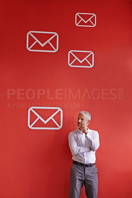 Buy stock photo Shot of a mature businessman standing against a red background filled with message symbols